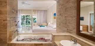 Junior Suite bathroom with a jacuzzi tub and double sinks, opening toward the bedroom and terrace