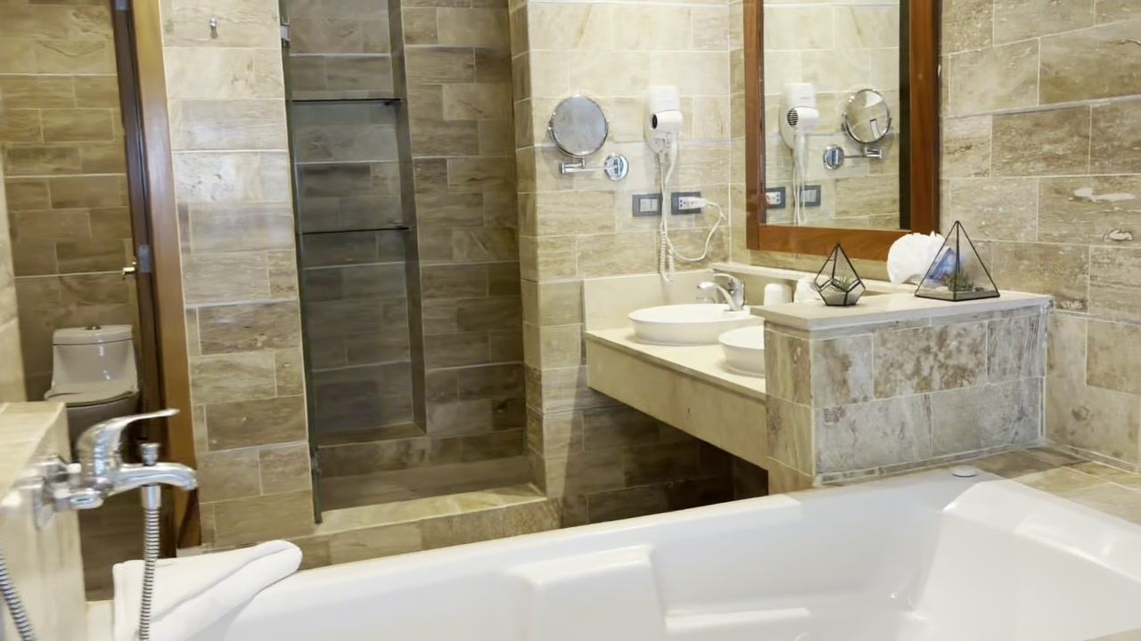 Stone bathroom with double vanity, shower and jacuzzi tub