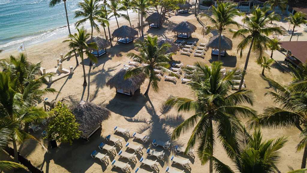 Aerial view of beach cabanas along the shore at The Tropical