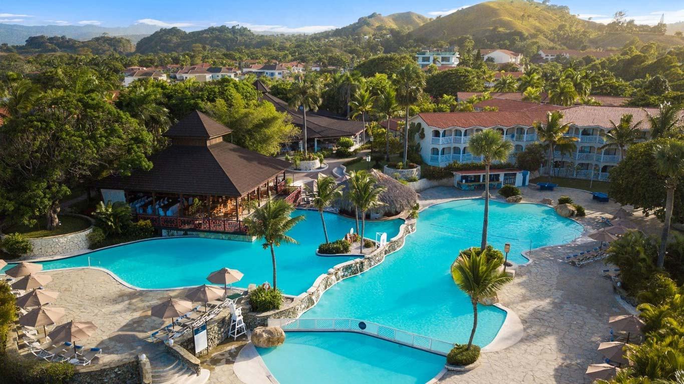 Aerial view of a palm-lined swimming pool at The Tropical