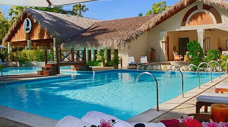 Pool and thatched-roof treatment buildings at the Yin Yang Spa